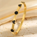 Vue détaillée d'un bracelet en acier titane doré avec des cœurs et cercles en émail noir - Or Noir Émail Cœur Bracelet