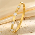 Gros plan d'un bracelet cœur en acier doré avec émail blanc sur fond de soie douce - Or Blanc Émail Cœur Bracelet