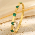 Gros plan d'un bracelet doré orné de cœurs à motifs rayés verts et noirs élégants - Or Vert Émail Cœur Bracelet