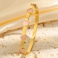 Vue détaillée du bracelet en titane doré avec des incrustations de cœurs roses - Or Rose Émail Cœur Bracelet