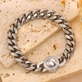 Détail macro du bracelet gourmette argenté avec fermoir rond serti de diamants sur pierre - Acier Fermoir Rond Zircone (NK)