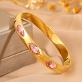 Goldener Edelstahl-Armreif mit drei rosa Markise-Steinen auf edlem Seidenhintergrund - Gold Marquise Rosa Zirkonia