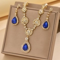 Close-up of gold jewelry set with blue pear-shaped stones and sparkling zircons - Gold Tone Sapphire Blue (1454 Gold Blue)