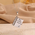 Detailed macro view of book-shaped stainless steel pendant engraved with My Little Star - Little Star Daughter All Silver