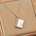 Detailed macro of silver stainless steel envelope pendant with heart hollow-out design - Silver