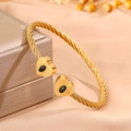 Gold cable bangle featuring heart charms and black stone inlay on warm gold background - Heart Black Turquoise (SZ838-1-1)