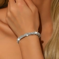 Detail of silver twisted multilayer bracelet with sparkling rhinestones on female wrist - Silver