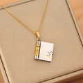 Macro detail of envelope book pendant necklace with hollow heart and gold steel chain - Gold & Silver