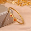 Golden twisted cable open bangle featuring heart ends with red stones on fabric - Heart Red Turquoise (SZ843-1-1)