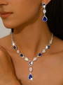 Detailed close-up of dark blue teardrop crystal necklace and earrings on female model - Necklace & Earrings Set (1662) / Sapphire Blue