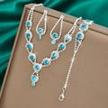Macro shot of silver jewelry set with sea blue stones and diamonds on silk background - Necklace Earrings And Bracelet Combination / Aqua