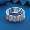 Vista macro di un bracciale elastico a 5 file in argento con strass lucidi su sfondo blu - Cinque file di diamanti / Argento