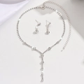 Macro detail of silver necklace and earring set with shimmering zircon crystals - Silver