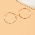 Close-up of golden hoop earrings with sparkling rhinestones on light background - Gold (Size 5)