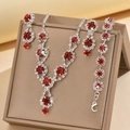 Close-up of silver bridal jewelry set with deep red ruby-style crystals and sparkling rhinestones - Necklace Earrings And Bracelet Combination / Red