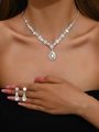 Detail of luxury teardrop necklace and drop earrings set on female model with crystal stones - Silver