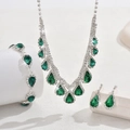 Detailed set of emerald zircon necklace, bracelet, and drop earrings on white pedestals - Green (3-Piece Set) / Green