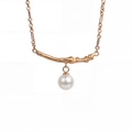 Detail of rose gold necklace with branch texture bar and hanging white round pearl charm - June-Milky White