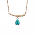 Detailed close-up of a gold branch necklace with a water-drop turquoise pendant - December-Turquoise Blue