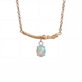Macro detail of rose gold branch texture and oval fire opal pendant on necklace - October-Opal Multi