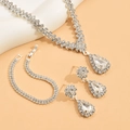 Nahaufnahme des Brautschmuck-Sets mit funkelnden Strasssteinen und Birnenschliff-Steinen - Weiße Halskette Ohrringe Armband
