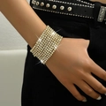 Close-up of sparkling gold stretch bracelets with white rhinestones on a model's wrist - Gold