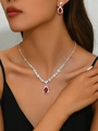 Close-up of elegant pear-shaped red sapphire pendant and earrings on a model for weddings - 695 Red