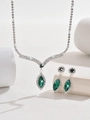Macro shot of V-shaped bridal jewelry set with green crystals and sparkling rhinestones - Emerald