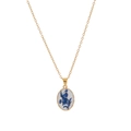 Close-up of oval white porcelain pendant with vintage blue floral patterns on gold chain - Blue Printed Necklace