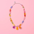 Primer plano de collar de cuentas coloridas con osito de goma y dijes de flores - Naranja