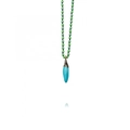 Macro view of a blue pepper pendant on a green beaded necklace with 18k gold plating - Sky Blue Chili Pendant / Sky Blue