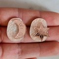 Macro shot of asymmetric celestial earrings with crescent moon and star shell texture - Champagne Moon Star Style
