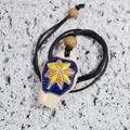 Detail of a handmade ceramic vase pendant with blue glaze and star pattern on black cord - Eight-petal Flower Necklace