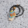 Close-up of ceramic butterfly whistle pendant with colorful glaze on stone surface - Butterfly Necklace
