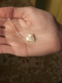 Silver-toned heart pendant necklace with star texture held in hand for scale - White Heart