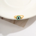 Macro shot of handmade gold wire-wrapped ring with blue evil eye bead detail - Style 1 Gold+Blue (0581)