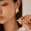 Dettaglio degli orecchini a foglia di ginkgo dorata con trama in metallo martellato - Oro (3203)