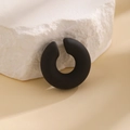 Macro view of C-shaped matte black ear cuff showing smooth texture and curved design - Black