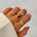 Set of four gold geometric rings with rhinestones and rubies shown on hand - Light Gold Vintage Gemstone Style