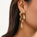 Irregular liquid metal style long earrings in bright gold finish on a model - Gold Toned Stud Earrings(3028)