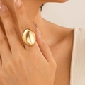 Gros plan d'une bague goutte d'or minimaliste avec une surface ovale polie sur une main - Or Clair (0738)