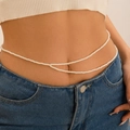 Détail d'une chaîne de corps double couche en perles portée sur un jean - Blanc