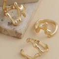 Detailansicht von drei unregelmäßigen goldenen Lava-Ringen auf einer Steinoberfläche - Lava Textur Unregelmäßig Set / Gold
