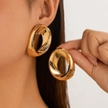 Par de pendientes de aro retorcidos dorados grandes con acabado metálico brillante en modelo - Pendientes de botón / Dorado