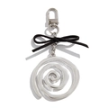 Close-up of a silver spiral keychain featuring a black velvet bow and lobster clasp - Pink Black Polka Dot Boots