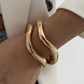 Set di bracciali a polsino in oro irregolare con trama metallica ondulata su modella - Combinazione Di Bracciale (5091) / Oro