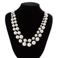 Detail view of double-layered faux pearl necklace on black velvet display stand - Silver White
