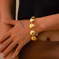 Pulsera de grandes cuentas doradas pulidas con acabado metálico brillante en la muñeca - Pulsera Dorada (2523)