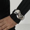 Detailed macro view of silver liquid metal wide cuff bracelet with wavy textured edges - Silver (2547)