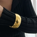 Detail of wide gold hammered cuff bracelet styled over a black sleeve for contrast - Gold (2539)